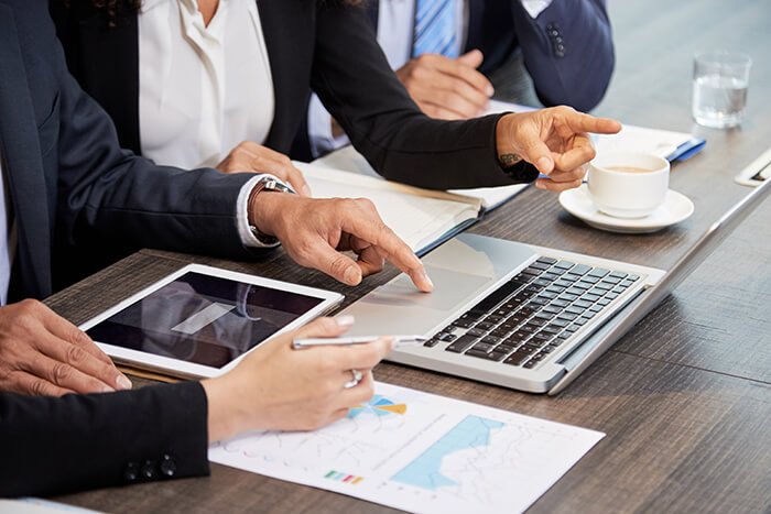 crop-colleagues-using-laptop-table (1)