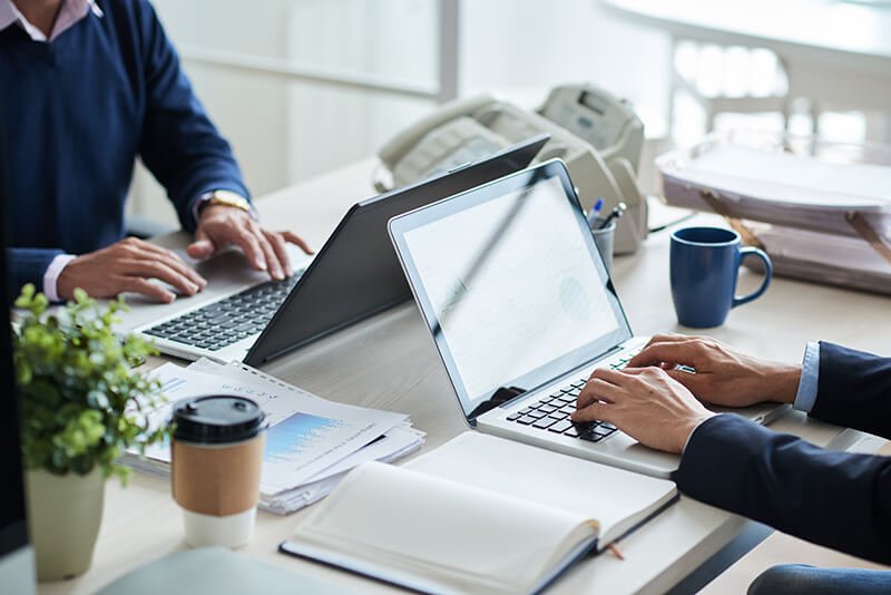 side-view-cropped-unrecognizable-business-people-working-common-desk (1)